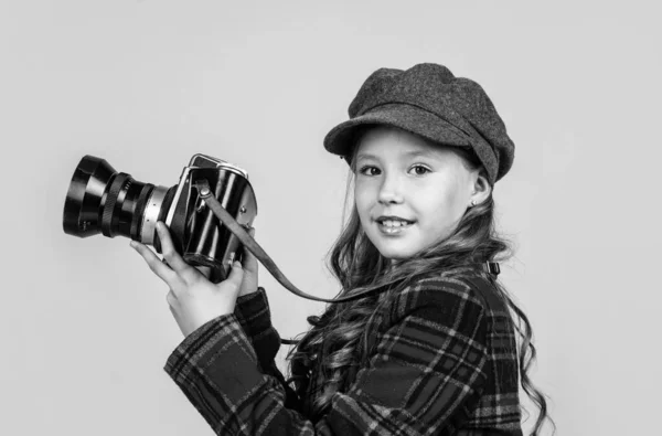 Criança alegre em headwear e jaqueta quadriculada usar câmera vintage, retro fotografar — Fotografia de Stock