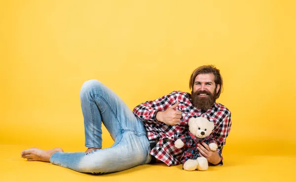 Tiempo para relajarse. Feliz cumpleaños. estar de buen humor. Feliz día de San Valentín. hombre barbudo alegre sostiene osito de peluche. macho se siente juguetón con oso. brutal maduro hipster hombre jugar con juguete —  Fotos de Stock