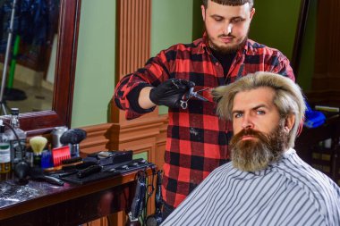 Seçiminden emin. Bıyıklı ve sakallı hippi. Adam yeni saç stili istiyor. Erkek güzellik ve moda. Berber dükkanında olgun bir adam. Kuafördeki vahşi sakallı adam. Erkek müşteriyle berber.