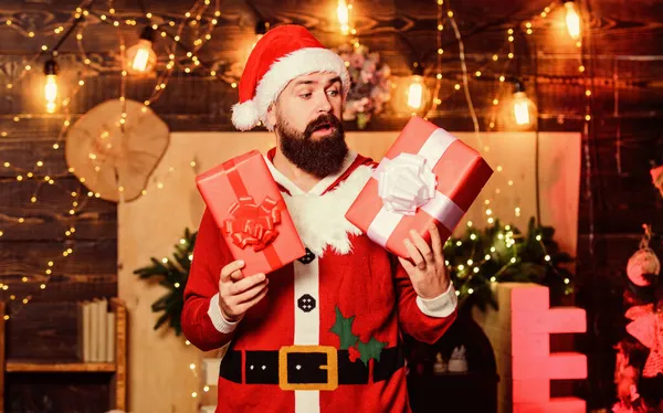 Сюрприз. зимние покупки. Веселый эльф. бородатый мужчина в шляпе Санты. бородатый Санта доставляет подарки. Рождественские покупки. Доставка рождественских подарков. С Новым годом. Рождественский подарок — стоковое фото