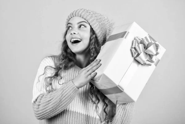 Kid hold present box. Happy winter holidays. Cheerful little girl knitted hat and sweater. Birthday surprise. Shopping mall concept. Birthday celebration idea. Good mood. Birthday tradition — Stock Photo, Image