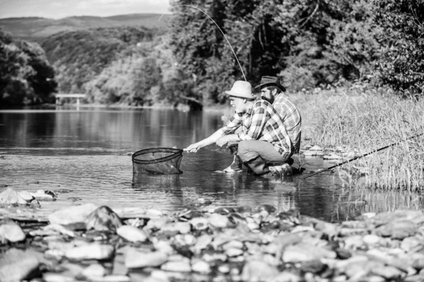 Giornata di famiglia. Fortunato e abile. Prendere il pesce con un amico. Gli amici catturano i pesci. Compagni pescatori. Spinning e placcaggio. Bella presa. Esche e amo. Hobby e tempo libero. Ottima presa. Uomini barbuti pesca — Foto Stock