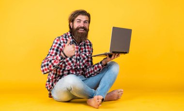 İnternete akın edin. Mutlu adam piyangoyu kazandı. Mesafe öğrenme. Başarıyı hisset. Coronavirus karantinasındayken evden çalışacağım. Dizüstü bilgisayarında çalışan hipster bir adamın portresi. Kendini izolasyon