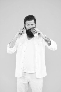 Vahşi hippi bardaktan içecek içiyor ve cep telefonuyla konuşuyor, iş iletişimi.