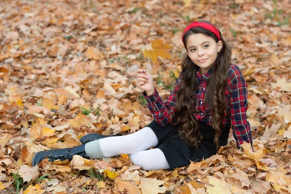 秋のファッション。制服を着た10代の少女が紅葉の上に座る。笑顔の子供 — ストック写真