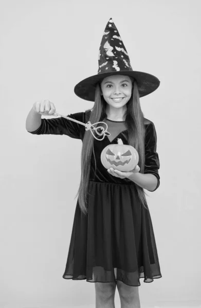 Probeer een spreuk. kind creëren wonder met toverstaf. Carnaval gekostumeerd feest. Snoep of ik schiet. Vier de feestdagen. Lantaarn. Halloween heksenmeisje. Gelukkige jeugd. kind in heksenhoed met pompoen — Stockfoto