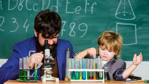 Creëren en investeren is goed bestede tijd. Kleine jongen met leraar man. zoon en vader op school. Chemie en fysica biologie. Wijsheid. Terug naar school. Kolf in de hand van een wetenschapper met reageerbuizen — Stockfoto