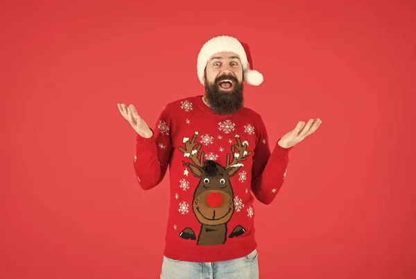 따뜻 한 뜨개질 스웨터를 입고 행복 한 수염을 가진 남자와 산타 클라우스 모자를 쓰고 성탄절을 축하하며 크리스마스 선물, 깜짝 선물에 대해 즐거운 기분을 느낀다 — 스톡 사진
