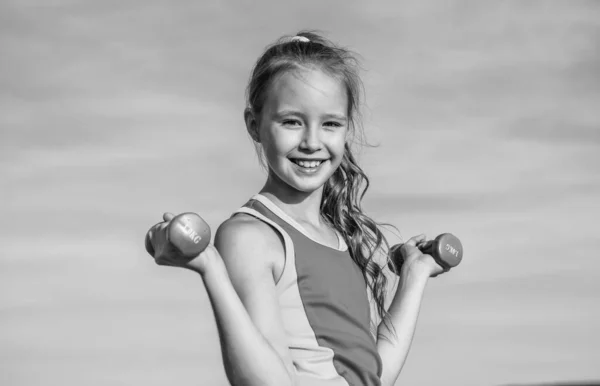 Boldog tini lány visel sportruházat edzés harangokkal az égen háttér, fizikai képzés — Stock Fotó