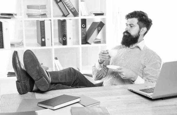 Hombre barbudo disfrutar de beber taza de té o café en el escritorio de la oficina, placer — Foto de Stock