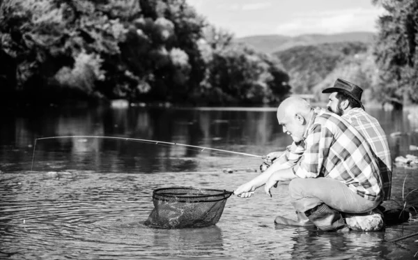 Emekli baba ve olgun sakallı oğul. İki erkek arkadaş birlikte balık tutuyor. Erkeklerin uçan balık hobisi. emeklilik balıkçılığı. Mutlu balıkçı arkadaşlığı. Büyük balık avı. Doğada rahatla. İyi kar — Stok fotoğraf