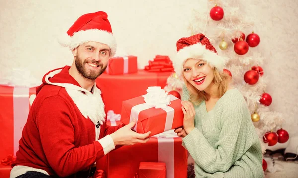 Αγαπώντας ζευγάρι αγκαλιά χαμογελώντας ενώ ξεπακετάρισμα δώρο χριστουγεννιάτικο δέντρο φόντο. Η οικογένεια ετοίμασε χριστουγεννιάτικα δώρα. Χριστουγεννιάτικο δώρο. Ζευγάρι ερωτευμένο χαρείτε τη γιορτή των Χριστουγέννων — Φωτογραφία Αρχείου