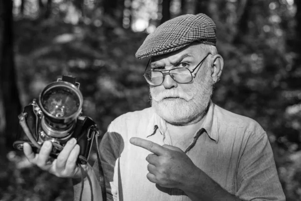 Stůj, nebo střelím. Starý kameraman ukazuje prstem na léto venku. Fotografování. Cestovní střelba. Najměte si fotografa. Zachytit vzpomínky z výletu — Stock fotografie