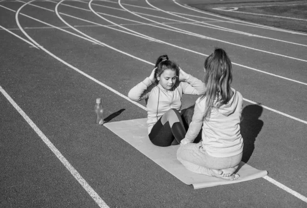 Niñas saludables entrenamiento fitness en pista de atletismo estadio, apoyo deportivo — Foto de Stock