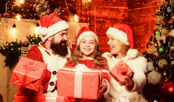 クリスマスのラッシュを打つ。サンタ・ハットの小さな子供と両親メリー・クリスマス父と母は娘を愛する。クリスマスプレゼント箱幸せな家族は新年を祝う。冬休みだショッピング販売 — ストック写真