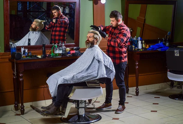 Kendi tarzında. Yakışıklı kuaför erkek müşterinin saçını kesiyor. Berber dükkanında müşteriye hizmet eden kuaför. Kişisel kuaför. Eski ve eski moda. Saç kesimi tasarlıyorum. Berber dükkanında berber aleti — Stok fotoğraf