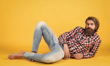 Moda görünüyor. Yakışıklı, kendine güvenen bir adamın mükemmel bir saç stili var. Kareli gömlekli mutlu sakallı adam. Erkek güzellik konsepti. Sakallı hippi portresi. Uzun, gür sakallı ve bıyıklı adam.