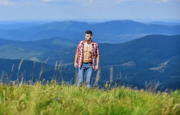 Wanderkonzept. Mann knöpft Hemd stehen oben Berglandschaft Hintergrund. Muskulöser Touristenspaziergang. Macht der Natur. Kräftiger muskulöser Oberkörper des Wanderers. Sportler muskulöser Typ entspannen Berge — Stockfoto