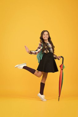 Mutlu ol ve okula git. Küçük çocuk sonbaharda okula geri dönüyor. Küçük kız okula sopa şemsiyesi ve sırt çantası taşıyor. Okul yağmurlu havada açıktır. Eğitim