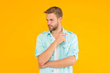 Havalı ve seksi. Sıradan gömlek giyen sakallı seksi adam. Erkek bahar modası. Erkek yüz bakımı ve güzellik. Modayı takip eden saç kesimi. Tıraşsız suratlı dalgın bir adam. poz modeli