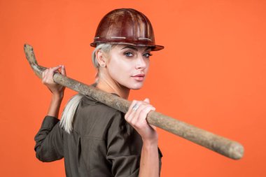 Daha derine in. Klimalı ve kasklı kadın. Kadın müteahhit kürek tutuyor..