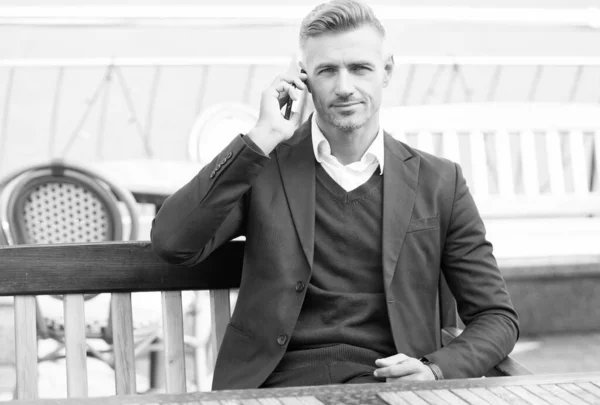 Självsäker affärsman i formell stil prata företag på smartphone-enhet mobil kommunikation vilar i utomhus café, teknik — Stockfoto