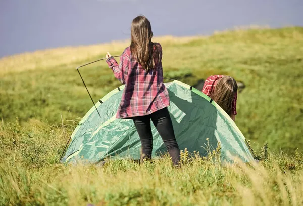 Caminhadas de acampamento. Útil ter parceiro para levantar tenda. As mulheres montaram tenda no topo da montanha. Actividade para caminhadas. Anexe a tenda de componentes estruturais necessária. Preparar para a noite. Conceito de escuteira — Fotografia de Stock