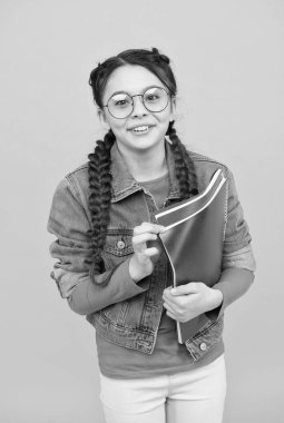 Yetiştirmek için iyi kitaplar oku. Mutlu çocuk kitapları sarı arka planda tutar. Kütüphane okuyucusu. Okumayı öğreniyorum. Ev ödevi. Okula dönelim. Edebiyat ve dil. Hayal gücü ve hayal gücü. Ara sıra oku.