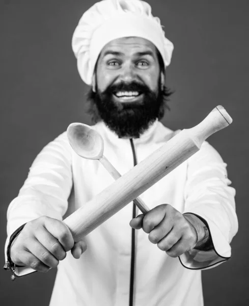 Впевнений шеф-кухар чоловік з бородою і вусами в кулінарній формі з використанням дерев'яної ложки і прокатного штифта, професійні навички — стокове фото