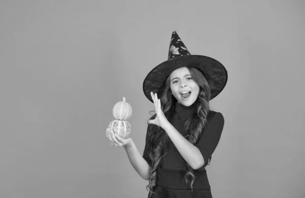 Sihir. Çocuk balkabağına büyü yapmış. Çocuk sonbahar tatilini kutluyor. Cadı şapkalı genç kız cadılar bayramını kutluyor. Cadılar bayramın kutlu olsun. Şeker mi şaka mı konsepti. Cadı karnavalı kostümü — Stok fotoğraf