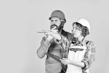 Yenileme konsepti. Tadilat için aile hesapları. Çift planlama yenileme dairesini değiştirir. Kadın ve erkek güvenlik kaskı takıyor. Yuvanın yenilenmesi. Belgelere bakan çift