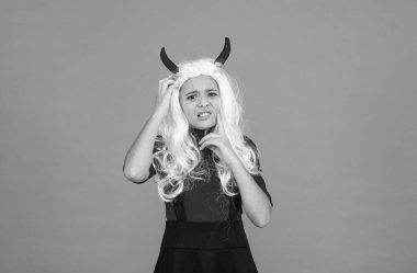 Şeytan boynuzları içindeki cadılar bayramı çocuğu şaşkın ve mutsuz, şaka mı şeker mi?