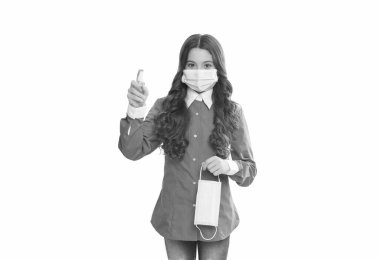 Doktor kız alkol bazlı el yıkama spreyi kullanıyor. Solunum maskeli bir çocuk. Koronavirüse karşı koruyucu önlem. Antibakteriyel dezenfektan jeli. Dezenfektan jeliyle el temizleme