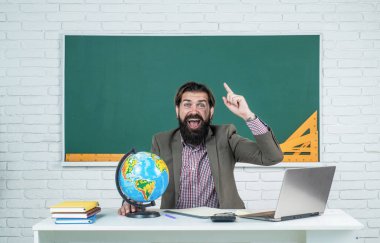 Coğrafya dersi veren üniversite hocası. Okula dönüyorum. gayri resmi eğitim. Mutlu, olgun bir öğretmen dünyaya bakıyor. Sakallı coğrafyacı sınıfında haritayla çalışıyor. Sınava hazırlan.