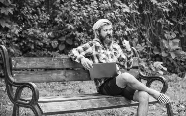 Temiz hava. Gezici internet. Modern laptop. Uzaktan kumanda. İnternetten alışveriş. Çevik iş. Sakallı adam yedek kulübesinde oturuyor. Çalış ve rahatla. İnternette çalışıyorum. Hipster parkta çalışmaktan esinlendi