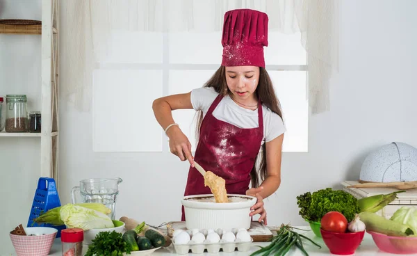 Various menus. kid cooking food in kitchen. choosing a career. little helper baking. culinary and cuisine. happy childhood. happy child wear cook uniform. chef girl in hat and apron — Stock Photo, Image