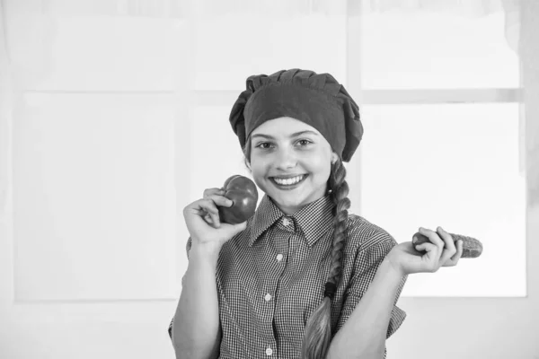 Fille enfant heureux dans le chapeau de cuisinier et tablier dans la cuisine, régime alimentaire — Photo