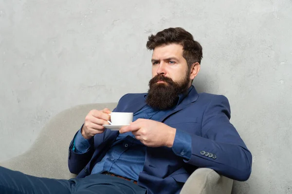 Bärtige Mann entspannen Tee oder Kaffee trinken in Ruhesessel während der Arbeitspause, entspannen — Stockfoto