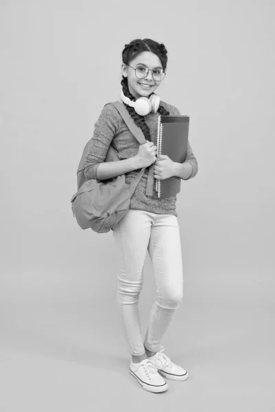 Moderní studentka s batohem a školní potřeby žluté pozadí, koncepce vzdělávacího systému — Stock fotografie