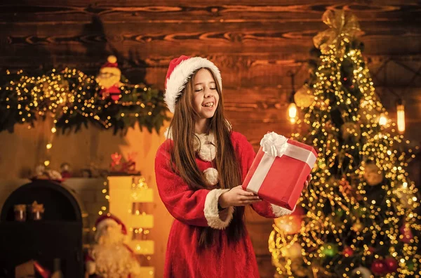 Papá Noel trajo regalos. Es hora de milagros. Todo lo que quiero para Navidad. Felicidad y alegría. Niño feliz chica emocionada encontrar regalos cerca del árbol de Navidad. Feliz navidad. Concepto de infancia feliz. Chico sombrero de santa —  Fotos de Stock