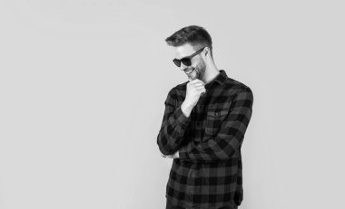 Yakışıklı, kendine güvenen, gözlüklü genç bir adam. Mutlu adam gülümsüyor. Gömlekli yakışıklı bir adamın portresi. Kareli baskılı klasik erkek gömlekleri. Boşluğu kopyala