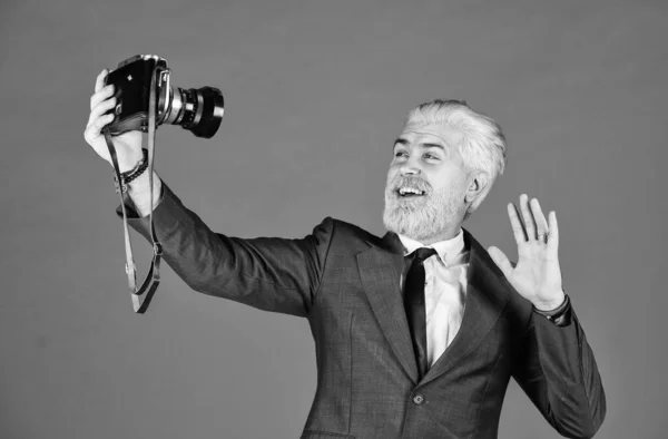 Ακολουθώντας το προσωπικό του στυλ. ώριμος άντρας έβαψε γένια και μαλλιά. επαγγελματίας φωτογράφος κάνει selfie φωτογραφία. Αποτέλεσμα σύλληψης του κομμωτηρίου. Μια παλιά κάμερα. χαρούμενος επιχειρηματίας κρατήσει ρετρό κάμερα — Φωτογραφία Αρχείου