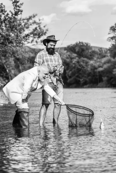 Día de la familia. padre jubilado e hijo barbudo maduro. Dos amigos pescando juntos. pasatiempo pez mosca de hombre de negocios. pesca de jubilación. pescadores felices. Buena ganancia. Concepto de captura y pesca —  Fotos de Stock