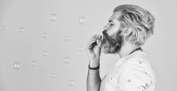 Feeling childish and childlike. real happiness. april fools day. bearded man blowing soap bubbles. carefree man with bubble blower. happy hipster in playful mood. Fall into childhood. copy space — Stock Photo, Image