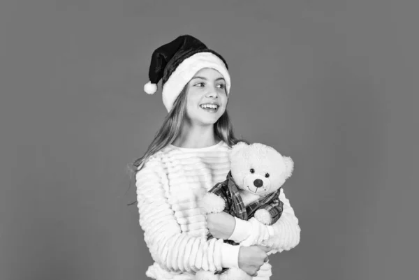 Prepararse para la fiesta de año nuevo. navidad vacaciones favoritas. invierno temporada alegre. venta de compras de Navidad. Papá Noel con juguete. niña santa claus sombrero rojo fondo — Foto de Stock