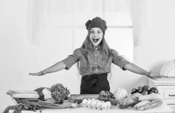 Счастливая девочка в кулинарной шляпе и фартуке на кухне, здоровье — стоковое фото
