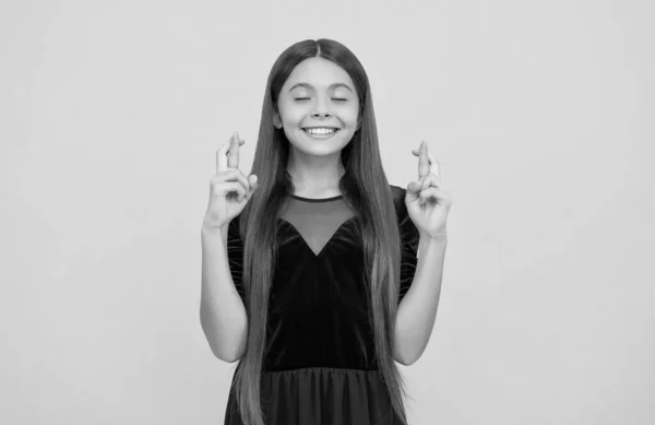 Bijgelovig klein kind met lang brunette haar in de mode jurk maken wens kruising vingers voor geluk, bijgeloof — Stockfoto