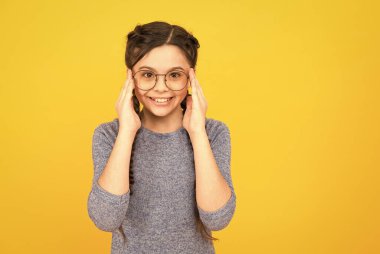 Göz aksesuarı kesinlikle işe yarar. Mutlu kız sarı arka plan gözlük takıyor. Moda aksesuarı. Tasarımcı gözlüğü. Bardaklar indirimde. Optik çerçeveler al. Moda aksesuar aslında aksesuar değildir, kopyalama alanı