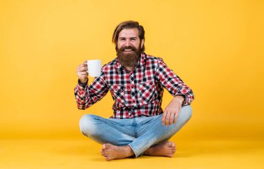 Mutlu sakallı adam sabah kahvesini içiyor. Adam fincandan sıcak çay içiyor. Sana da günaydın. Enerjik, sıcak bir içecek. İlham için biraz kahveye ihtiyacım var. Güne mükemmel bir başlangıç