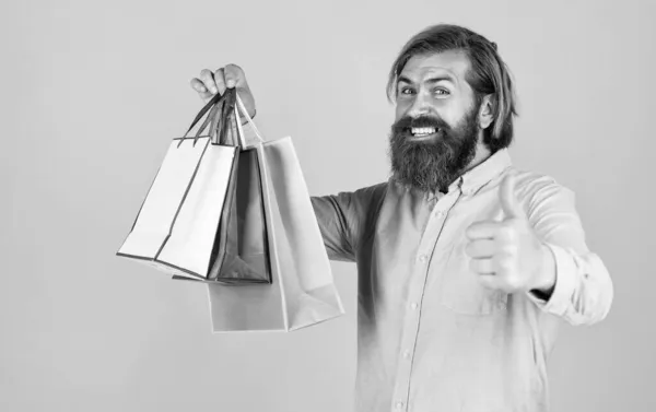 Brutální vousatý muž drží dárek nebo dárkový balíček, černý pátek — Stock fotografie